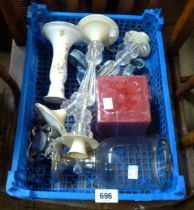 A small crate containing a quantity of candlesticks including ceramic, glass, etc.