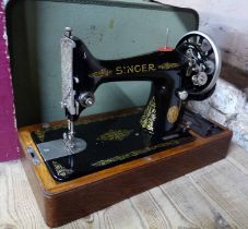 A vintage Singer sewing machine, in domed wooden case