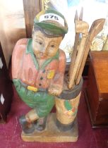 A carved and painted wood figurine depicting a golfer