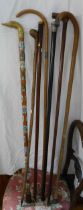 A quantity of antique and later walking sticks and canes including silver and yellow metal topped,