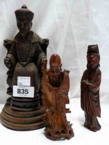 A vintage resin figurine depicting a seated Chinese emperor - sold with two carved wood Oriental