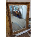 A reproduction gilt framed bevelled oblong wall mirror with decorative border - 76cm X 1.05m