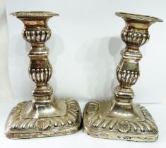 A pair of 17.5cm high silver candlesticks with embossed, reeded and shell decoration, set on