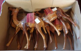 A box containing four carved wood camel figurines