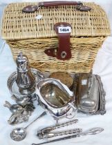 A wicker basket containing a quantity of silver plated items including butter dish, coaster and a