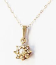 A 375 (9ct.) gold pendant, set with central pearl within a tiny diamond border, on fine link neck