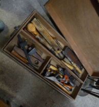 A wooden box with lift-out tray containing a quantity of tools including planes, chisels, etc.