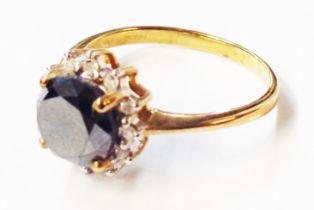 A 375 (9ct.) gold ring, set with central black diamond within a diamond chip border - size N