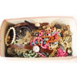 A shoebox containing a quantity of assorted costume jewellery and several modern wristwatches