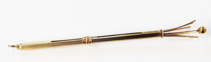 A 375 (9ct.) gold telescopic swizzle stick with engine turned decoration and suspender loop