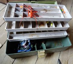 A fishing box containing quantity of fishing items including reel, lures, etc.