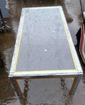A modern glass topped coffee table with gilt highlighting