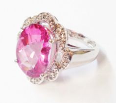 An import marked 585 (14ct.) white gold ring, set with large central oval pink topaz within a shaped