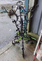 A wrought iron triple plant stand of pierced scroll design