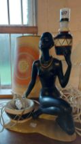 A 1950's plaster table lamp in the form of an African lady, with contemporary shade