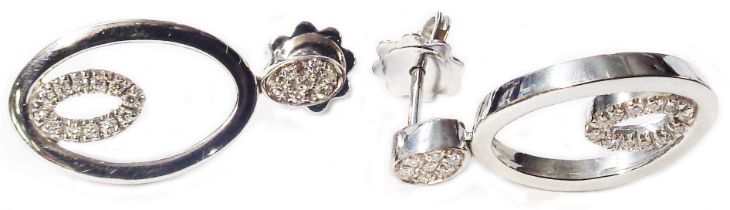 A pair of marked 750 white metal open oval panel earrings, each with diamond encrusted centre and