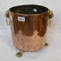 An old copper jardiniere with cast brass lion mask handles and paw feet