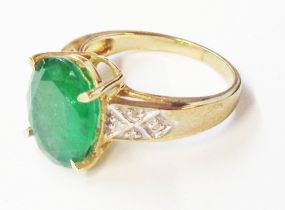 A 375 (9ct.) gold ring, set with central 4.19ct. oval Brazilian emerald and tiny diamonds to