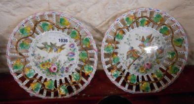 A pair of Lille French faience plates with pierced rims and central hand painted panels depicting