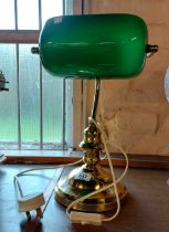 A modern brass banker's style lamp with green glass shade