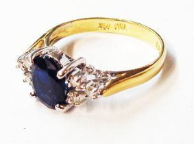 A marked 750/18k yellow metal ring, set with central oval sapphire and six flanking tiny