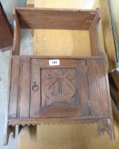 A 36cm vintage stained pine shelf unit with carved lyre decoration to single panelled cupboard door,