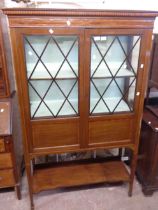 A 1.04m Edwardian inlaid mahogany display cabinet with material lined shelves enclosed by a pair