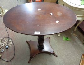 A 63.5cm antique mahogany oval topped pedestal table, set on turned and reeded pillar with