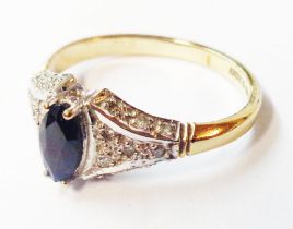 A 375 (9ct.) gold ring, set with central marquise shaped sapphire and tiny diamonds to shoulders -