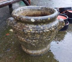 A large cast concrete planter of urn form with moulded decoration