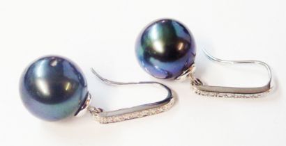 A pair of marked 750 white metal black pearl drop earrings with diamond encrusted suspenders -