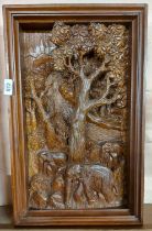 A large intaglio carved wooden panel, depicting elephants in a forest