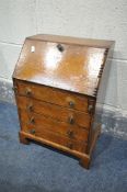 A MINIATURE OAK GEORGIAN STYLE BUREAU, with a fall front enclosing a single drawer, over four