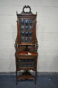 AN EDWARDIAN MAHGOANY CORNER CABINET, made up of two tiers, with two cupboard doors with rounded