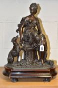 A SPELTER FIGURE OF DIANA, in Classical dress, seated on a column, with a hunting dog and a sheath