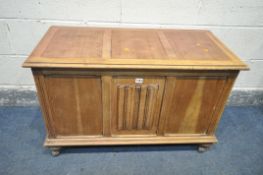 AN OAK LINENFOLD BLANKET BOX, with hinged lid, and later casters, width 96cm x depth 48cm x height