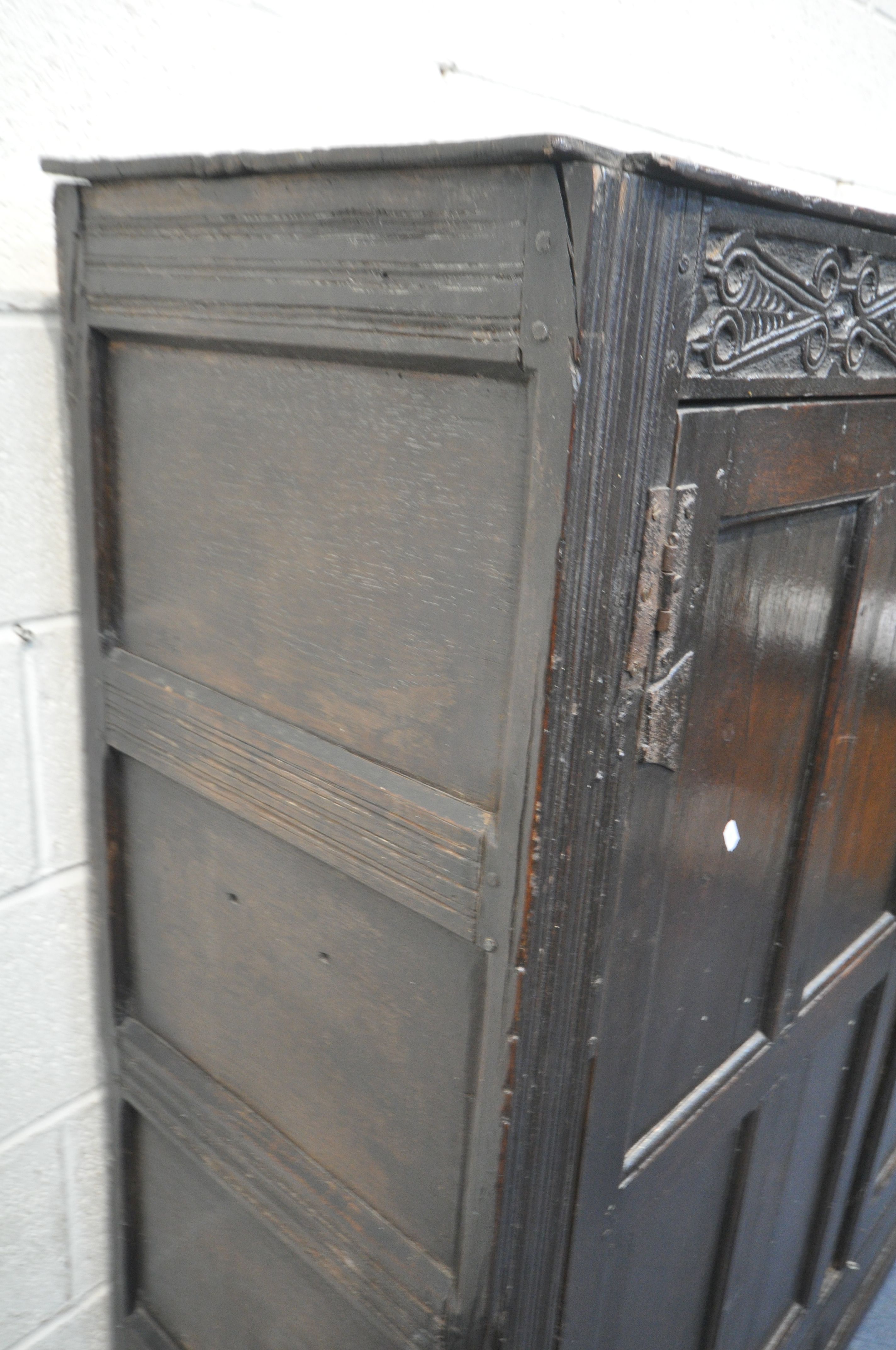 A 17TH CENTURY JOINED OAK CUPBOARD, with a carved top rail, and initialled I.H.E, the double doors - Image 4 of 9