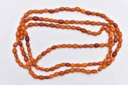 A NATURAL AMBER BEAD NECKLACE, one hundred and forty three amber beads, oval form, slightly