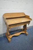 A VICTORIAN PINE WASHSTAND, with a raised back, over a trestle base united by a shaped stretcher,