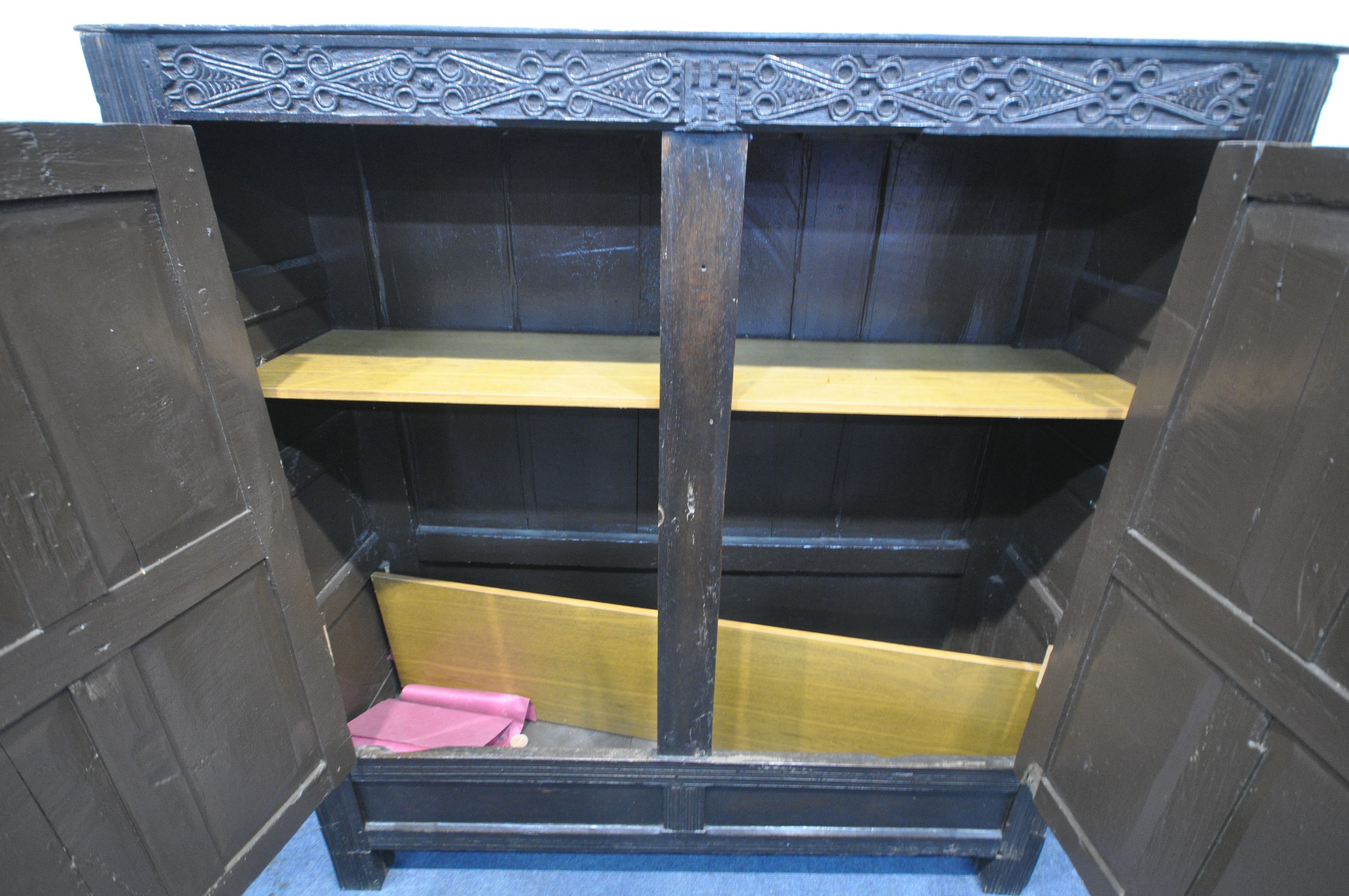 A 17TH CENTURY JOINED OAK CUPBOARD, with a carved top rail, and initialled I.H.E, the double doors - Image 9 of 9