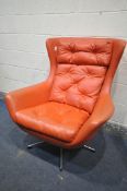 A MID CENTURY RED LEATHERETTE SWIVEL ARMCHAIRM with a buttoned back and seat, on a chrome base,