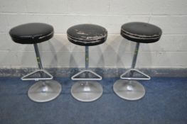 A SET OF THREE MID-CENTURY INDUSTRIAL HIGH STOOLS, with black leatherette seats, and shaped