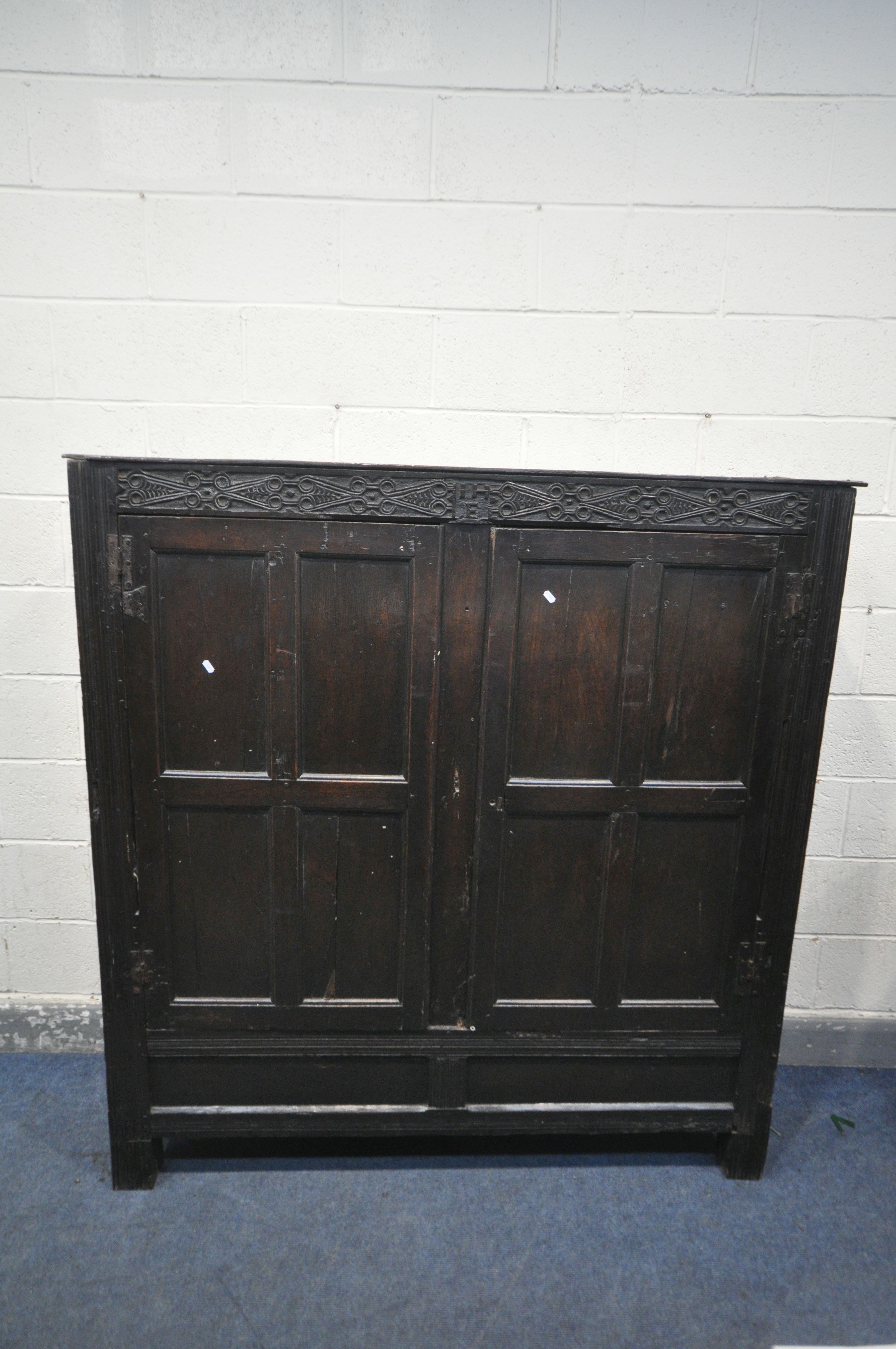 A 17TH CENTURY JOINED OAK CUPBOARD, with a carved top rail, and initialled I.H.E, the double doors - Image 2 of 9