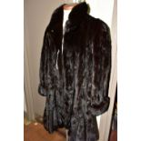A DARK BROWN MID LENGTH MINK SWING COAT, with a frilled hemline, size large, length from shoulder