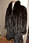 A DARK BROWN MID LENGTH MINK SWING COAT, with a frilled hemline, size large, length from shoulder
