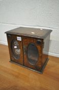 AN EARLY 20TH CENTURY OAK SMOKERS/PIPE CABINET, with a hinged top, and double doors with oval