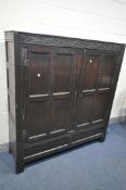 A 17TH CENTURY JOINED OAK CUPBOARD, with a carved top rail, and initialled I.H.E, the double doors