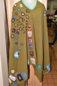A VINTAGE GIRL GUIDES GREEN CAMP BLANKET, with a quantity of hand sewn Girl Guide, Brownie and Scout