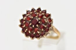 A 9CT YELLOW GOLD GARNET CLUSTER RING, large cluster of circular cut garnets, approximate cluster