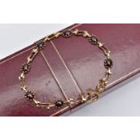 A 9CT YELLOW GOLD GARNET BRACELET, set with seven garnet cabochons, each claw set to a collet mount,